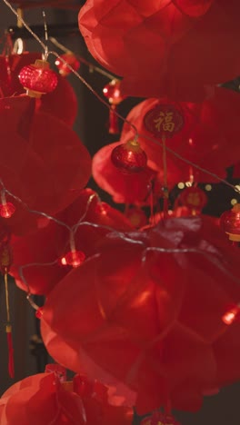 Vertical-Video-Close-Up-Of-Decorative-Lights-With-Chinese-New-Year-Lanterns-In-Background-2